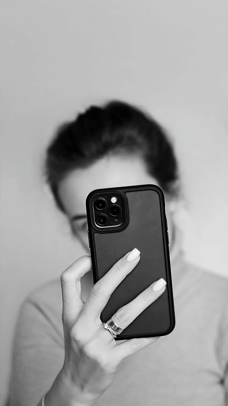 A close-up of a woman framing her own photograph on a smartphone